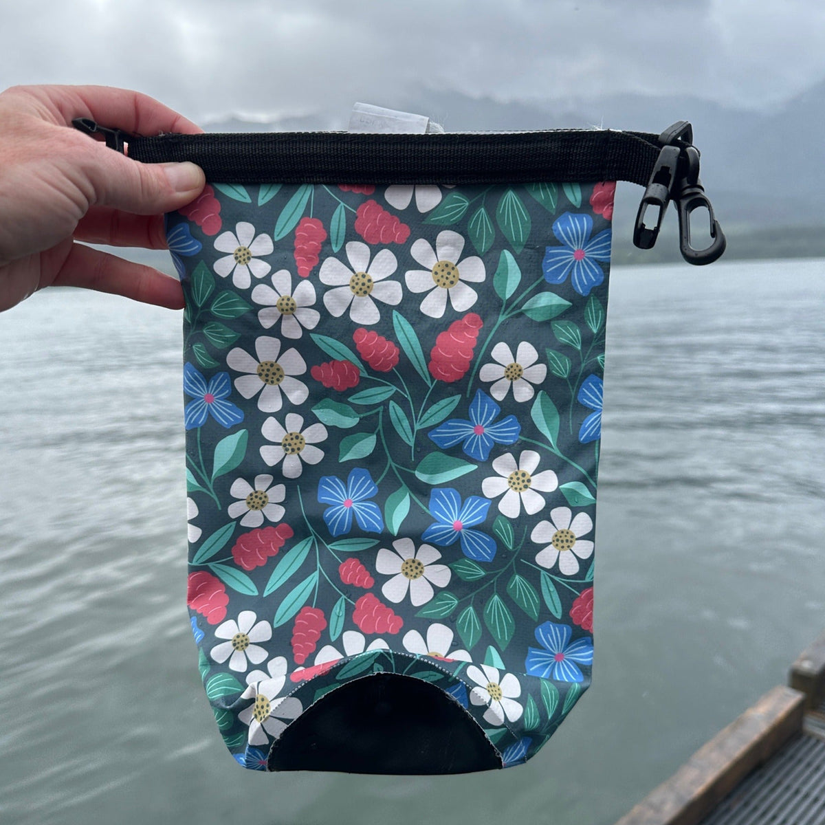 Floral dry bag set against a gray sky and gray water