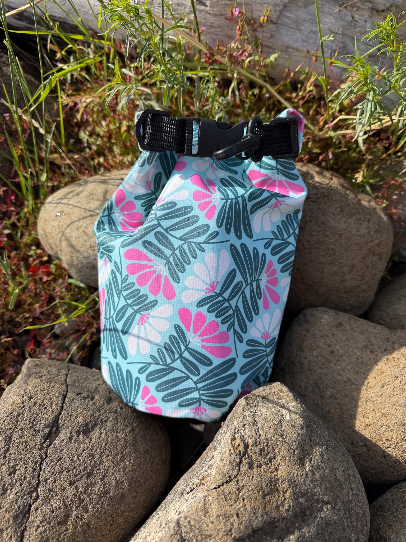 Floral dry bag on rocks and grass