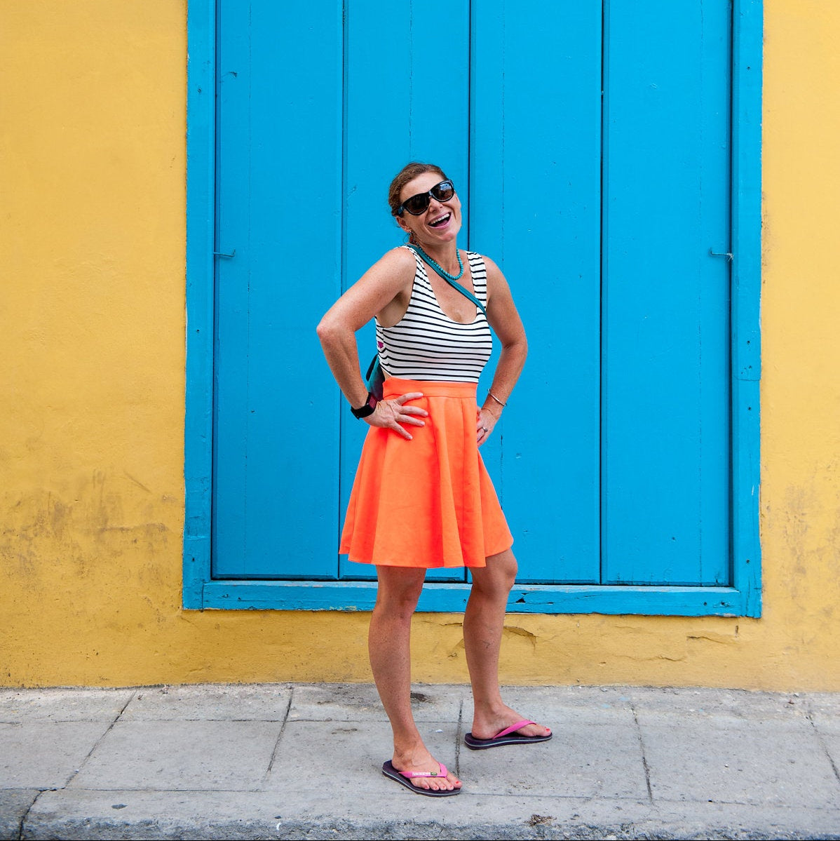 girl in bright skirt next to blue and yellow wall