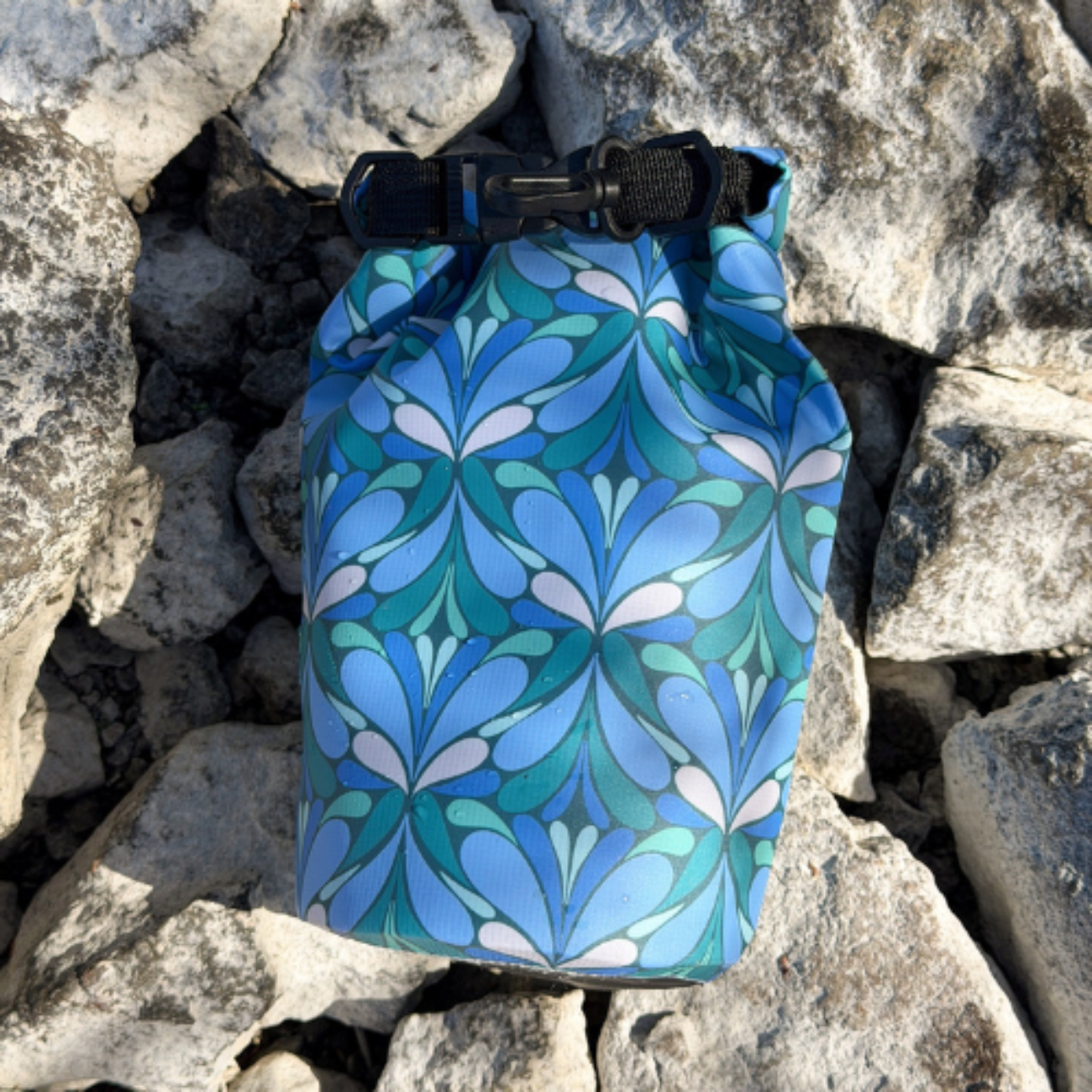 Blue patterned drawstring bag on a rocky surface