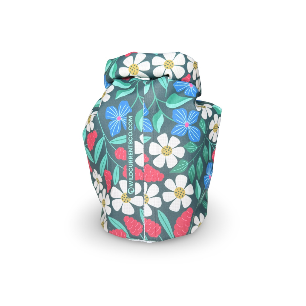Side view of a white-accented dark green floral dry sack showing the stitched seam structure and rolled-top buckle closure.