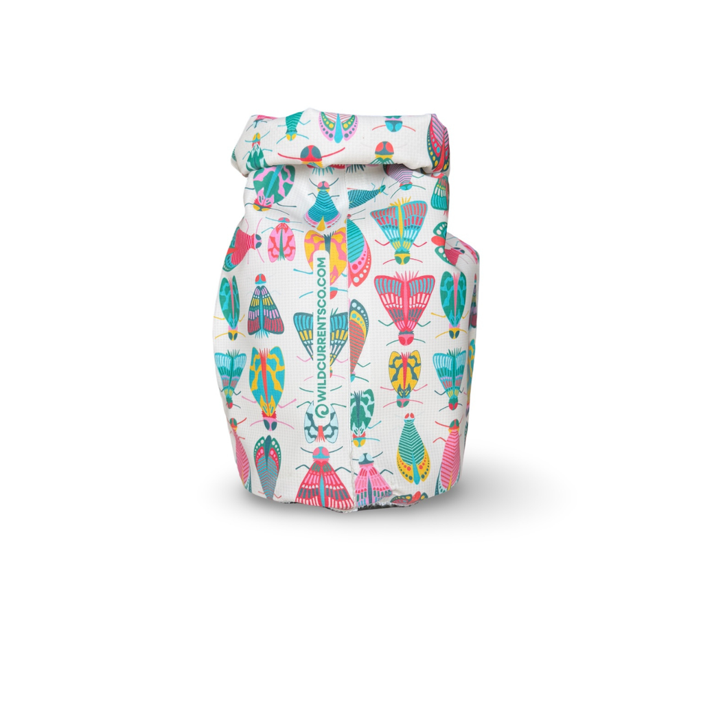 Rear view of a white waterproof dry sack covered in vibrant bug illustrations, showing the folded roll-top closure.