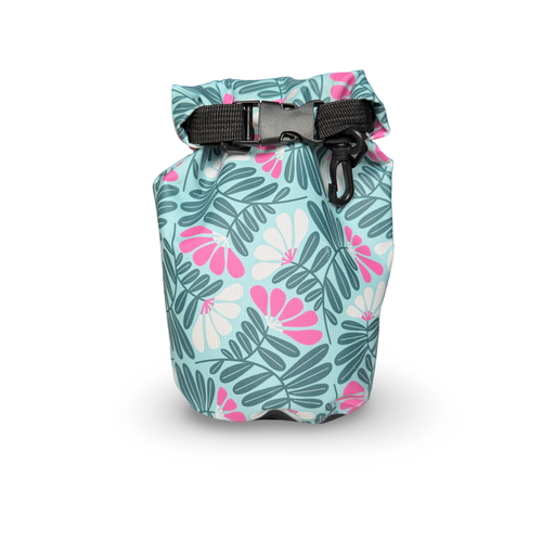 Wild Current compact waterproof dry bag featuring a tropical green leaf and pink floral pattern on a white background.
