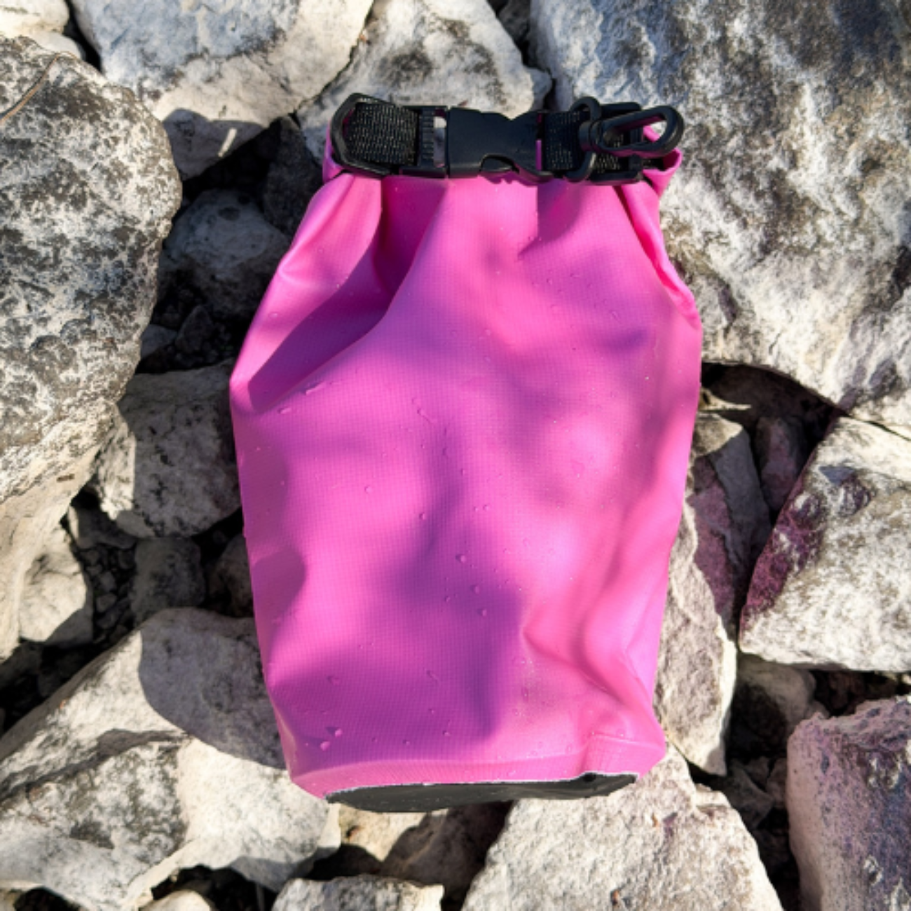 Pink waterproof bag on a rocky surface