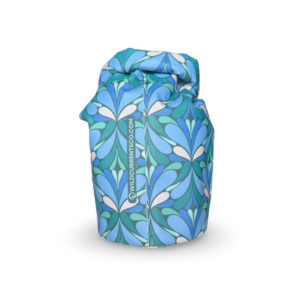 Side view of a blue and green patterned waterproof dry sack showing the stitched seam and roll-top design